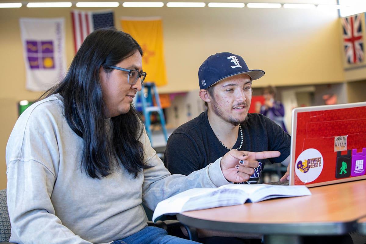 SJC students looking at laptop.